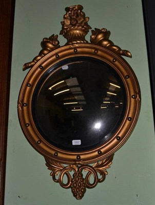 Lot 1007 - A Regency style gilt convex wall mirror with ebonised slip