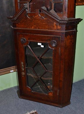 Lot 1015 - A George III oak and mahogany crossbanded hanging corner cabinet, 114cm by 80cm by 42cm