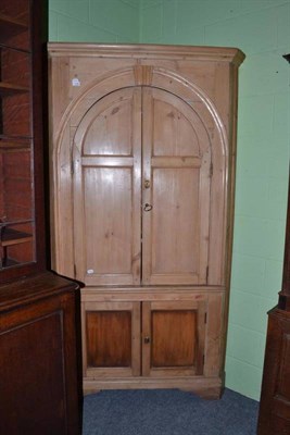 Lot 1146 - A late 18th century pine standing corner cupboard, with a pair of arched doors over a pair of...