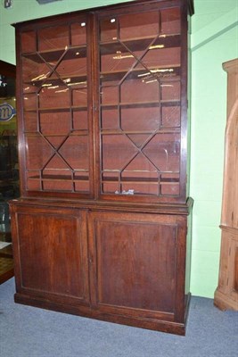 Lot 1147 - George III mahogany bookcase with a pair of glazed doors over panel doors with key