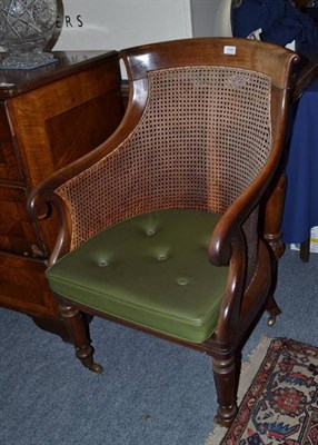 Lot 1165 - A Regency mahogany bergere armchair with caned back and seat on castors (damages to the frame)