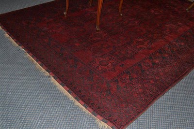 Lot 1206 - Afghan carpet Afghan Turkestan the claret field with three columns of medallions enclosed...