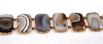 Lot 105 - An Agate Bracelet, the oblong banded agate panels in yellow claw settings, length 18.3cm