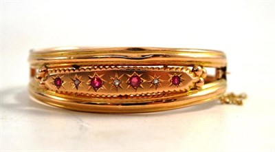 Lot 260 - A Victorian Ruby and Diamond Set Bangle, a central panel inset with alternating rubies and...