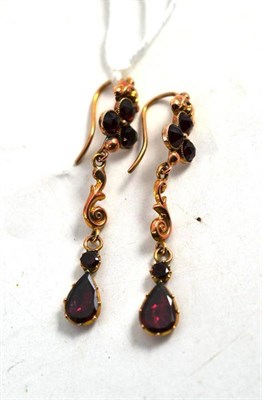 Lot 270 - A Pair of Foil Backed Garnet Earrings, a trefoil of rose cut stones suspends a scroll drop and...