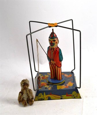 Lot 337 - A Schuco Monkey Scent Bottle, 9cm; and A Tinplate Fishing Man, 19cm high (2)