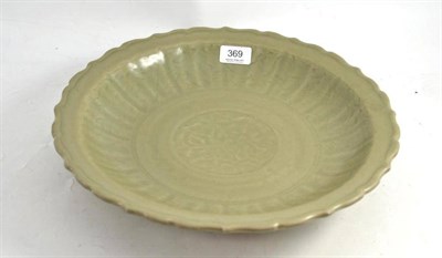 Lot 369 - A Longquan Celadon Dish, Ming Dynasty, carved with a lotus blossom in a circular panel within a...