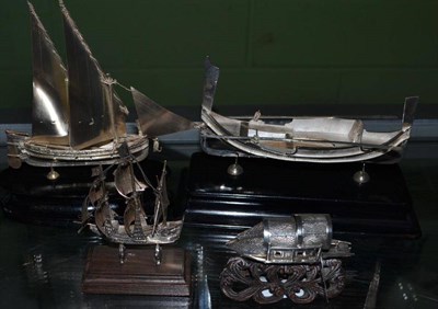 Lot 607 - A Chinese Silvered Metal Model of a Junk, 7cm long, on a wooden base and Three Silvered Metal Model