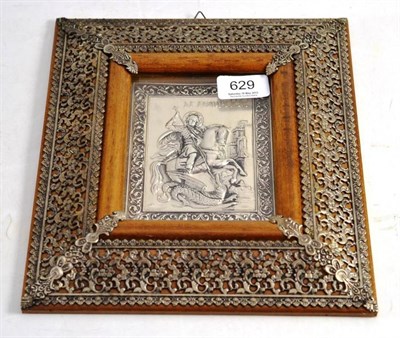 Lot 629 - A White Metal Plaque Depicting St George and The Dragon mounted in a foliate frame 13cm by 10cm