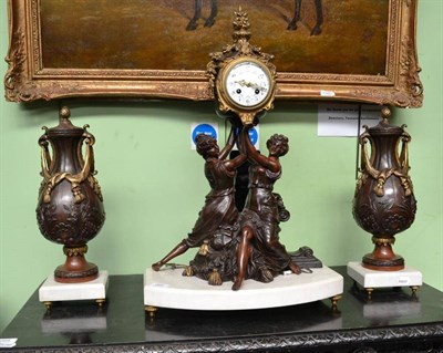 Lot 669 - A French Bronzed and Marble Striking Mantel Clock Garniture, circa 1900, the figural case with...