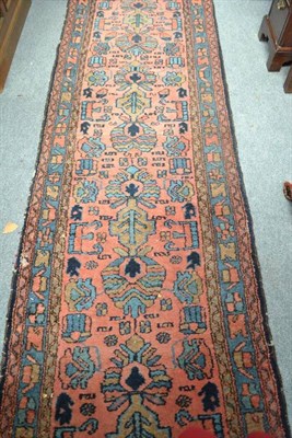 Lot 696 - Narrow Hamadan Runner  Persian Kurdistan The coral pink field with a column of stylised plants...