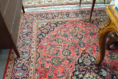 Lot 720 - Kashan Design Carpet The raspberry field of scrolling vines around an indigo central medallion...