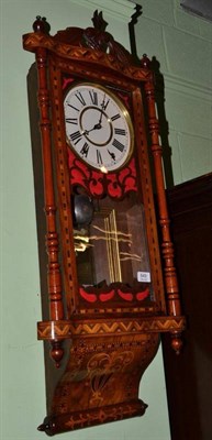 Lot 849 - A Walnut and Inlaid Striking Wall Clock, circa 1890, carved cresting, glazed front door, 8-inch...