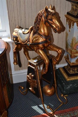 Lot 871 - A Gilt Rocking Horse, of recent date, raised on a metal platform base, height 98cm