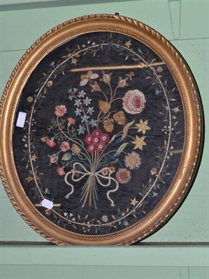 Lot 1069 - A George III Oval Silkwork Picture, depicting a ribbon-tied bunch of flowers, 50cm by 44cm, framed