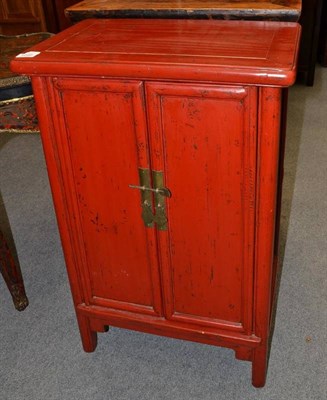 Lot 1240 - A Chinese Red Lacquer Two Door Cabinet, 20th century, with cupboard doors and decorative apron,...