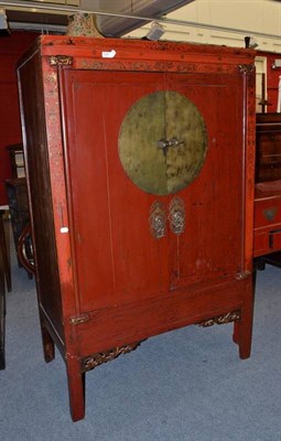 Lot 1251 - A Chinese Red Lacquer and Parcel Gilt Decorated Two-Door Cabinet, 20th century, with brass look...