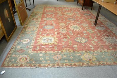 Lot 1264 - Heriz Design Carpet The terracotta field with an allover design of flower head medallions...