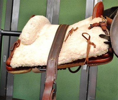 Lot 1449 - A Leather Western Saddle, with punched decoration to the fork and horn, sheepskin covered seat...