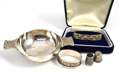 Lot 15 - A silver quaich, a silver bangle, a silver napkin ring and two silver thimbles