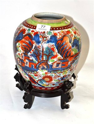Lot 77 - A Chinese blue and white 'clobbered' ginger jar on wood stand, 24cm high
