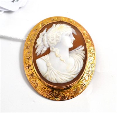 Lot 261 - A cameo brooch in a scroll patterned frame stamped '9CT'