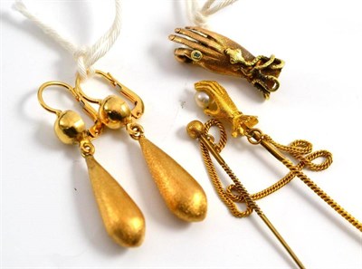 Lot 269 - A pair of earrings, a hand charm and a stick pin as a hand