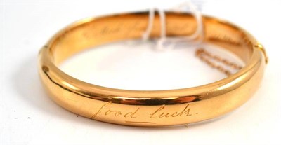 Lot 297 - An un-hallmarked hinged and engraved bangle