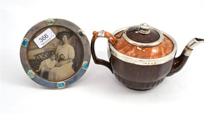 Lot 366 - An Arts and Crafts circular silver photograph frame set with cabochons, and a silver mounted teapot