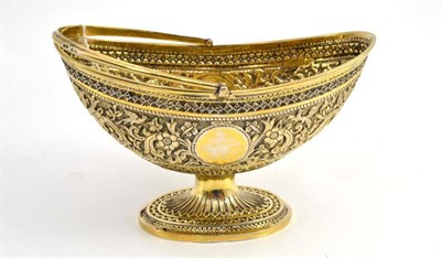 Lot 383 - A Victorian silver gilt sugar basket, of boat shape with swing handle and splay foot, heavily...