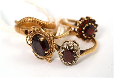 Lot 431 - A garnet set snake ring and three other garnet set rings (4)