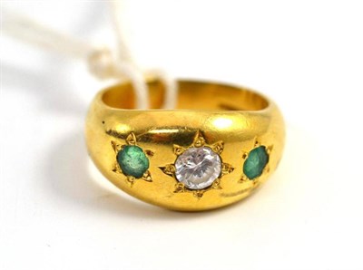 Lot 442 - An 18ct gold cubic zirconia and emerald three stone ring