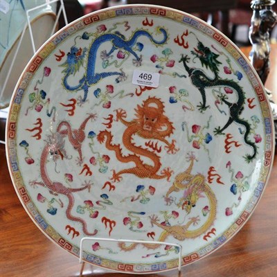 Lot 469 - A 20th century Chinese famille rose shallow dish decorated with coloured dragons amongst cloud...