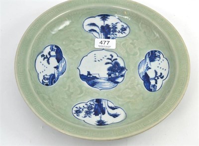 Lot 477 - A 20th century Chinese celadon ground dish decorated with lobed panels in under glaze blue,...