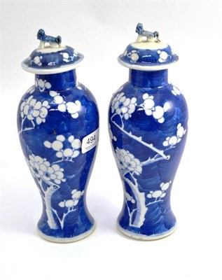 Lot 494 - Pair of Chinese blue and white porcelain prunus and crackled ice vases and covers, 23cm high