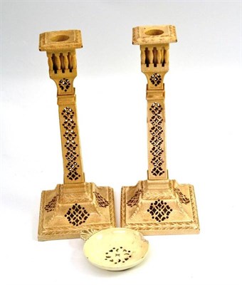 Lot 496 - A pair of Leeds creamware candlesticks and a Leeds creamware egg strainer (2)