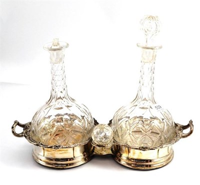 Lot 509 - A silver plated double decanter coaster engraved with a family crest and two glass decanters...