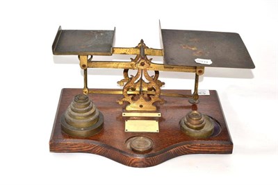 Lot 536 - A set of brass postal scales and weights on an oak base