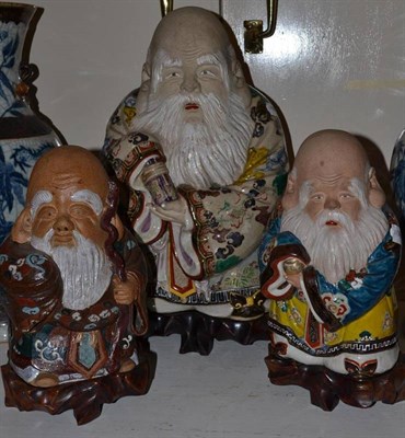 Lot 540 - A set of three early 20th century Chinese polychrome painted figures of Sages on hardwood...