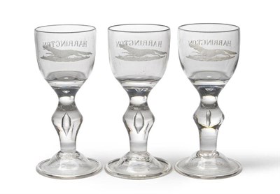 Lot 569 - A set of three heavy baluster wine glasses, the ovoid bowls with solid bases engraved...