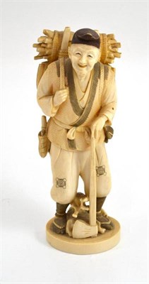 Lot 612 - A Japanese elephant ivory carved figure of a woodman, Meiji period (1868-1912), faggots on his...