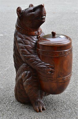 Lot 729 - A Black Forest carving realistically modelled as a seated growling bear holding a barrel with...