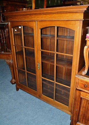 Lot 806 - An early 20th century oak and glazed bookcase, width 127cm