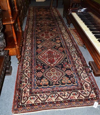 Lot 890 - North West Persian Runner, The deep indigo field with a column of diamond medallions enclosed...