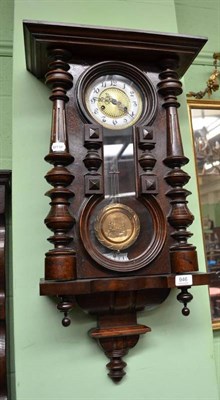 Lot 946 - A Continental walnut wall clock with decorative brass pendulum, height 80cm