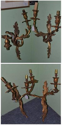 Lot 992 - A set of four gilt metal double branch wall lights of foliate scroll form, each approximately 48cm