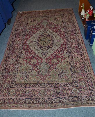 Lot 1004 - A Kirman Rug South East Persia The claret field of palmettes and vines around an ivory pole...