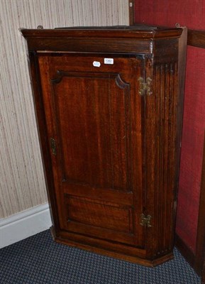 Lot 1382 - An 18th century oak and mahogany cross banded hanging corner cupboard, height 113cm