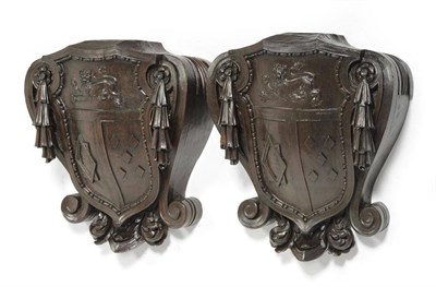 Lot 1395 - Pair of carved brackets with a coat of arms and decorative swags, height 63cm