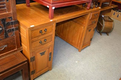 Lot 1503 - A Chinese twin pedestal writing desk with two drawers and a cupboard to each pedestal, 141cm wide